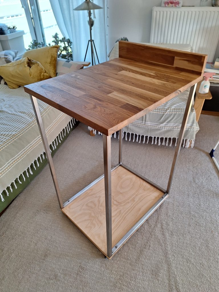 Ein Servierwagen aus Edlestahl und Eiche mit Rollen für einen Espressomaschine